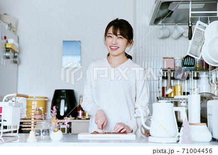 キッチンでチョコレートをカットする女性 キッチンでチョコレートをカットする女性 71004456