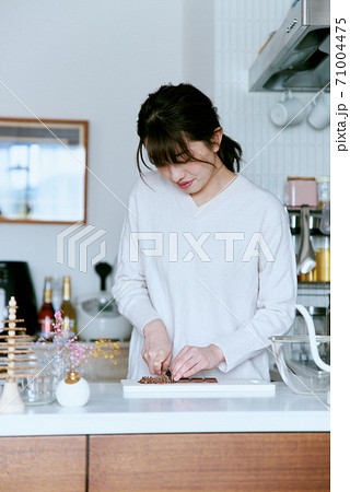 キッチンでチョコレートをカットする女性 71004475