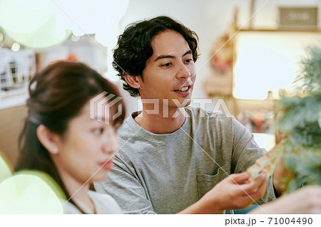 クリスマスツリーに飾り付けをする女性と男性 71004490