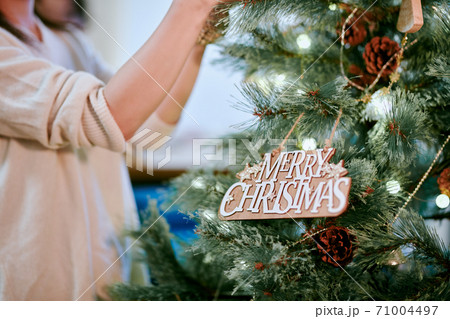 クリスマスツリーに飾り付けをする女性 71004497