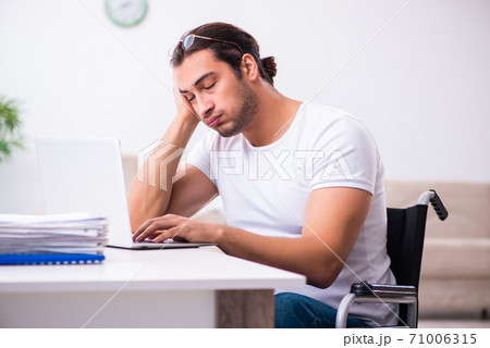Young disabled man working from house Young disabled man working from house 71006315