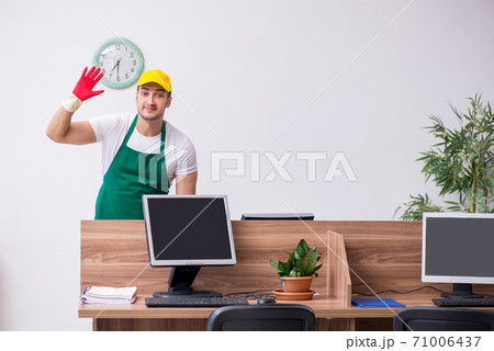 Young male contractor cleaning the office Young male contractor cleaning the office 71006437