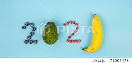 2021 Happy New Year and New You with fruits; Blueberries, Avocado, Pomegranate seeds and banana on blue background. Goals, Healthy, Resolution, Time to New Start and dieting concept 71007478