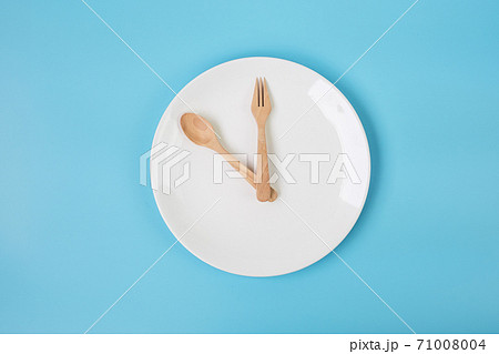 Top view white ceramic plate with knife, spoon and fork on blue background. Intermittent fasting, Ketogenic dieting, weight loss, meal plan and healthy food concept Top view white ceramic plate with knife, spoon and fork on blue background. Intermittent fasting, Ketogenic dieting, weight loss, meal plan and healthy food concept 71008004