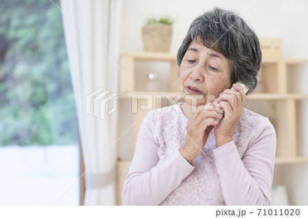 不審な電話に出るシニア女性 71011020