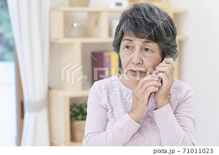 不審な電話に出るシニア女性 71011023