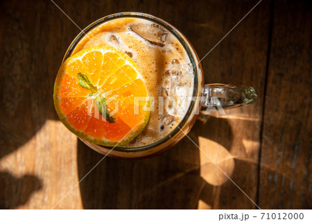 espresso shot mixed with soda on bottom in transperant glasses mug with coffee bubble topping by orange mint on wooden table in morning light refreshment stock photo espresso shot mixed with soda on bottom in transperant glasses mug with coffee bubble topping by orange mint on wooden table in morning light refreshment stock photo 71012000