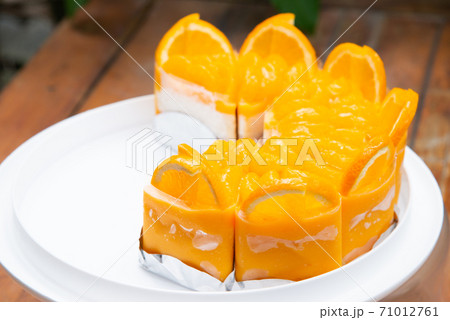 a lot of real orange cake wrap by foil and plastic on white plate and wood table stock photo a lot of real orange cake wrap by foil and plastic on white plate and wood table stock photo 71012761