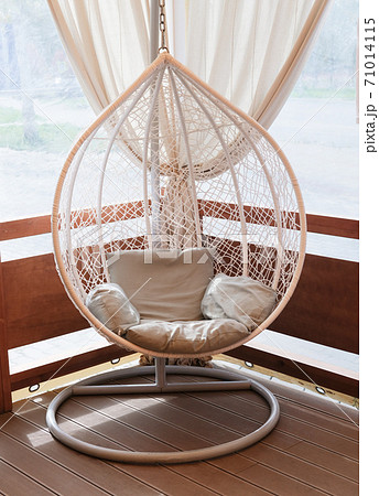 Wicker rattan hanging chair nest on a terrace Wicker rattan hanging chair nest on a terrace 71014115