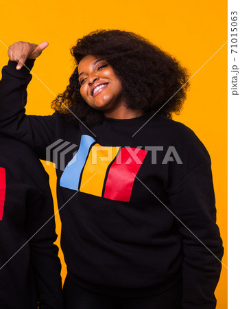Young beautiful african american girl with an afro hairstyle. Portrait on yellow background. 71015063