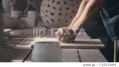 Crop potter kneading clay on board Crop potter kneading clay on board 71015964