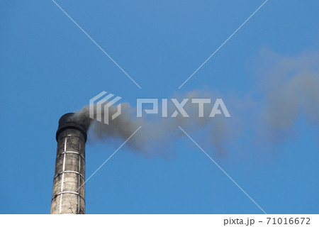 古い煙突から立ち上る黒い煙と青空 71016672