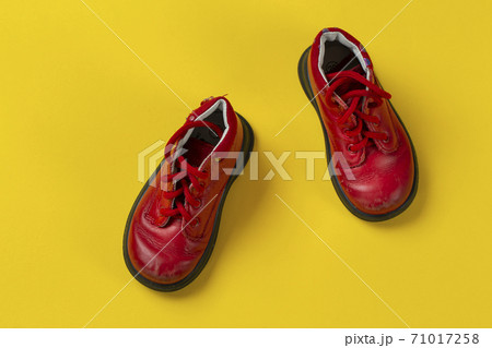 Children's leather shoes in red on a yellow background. Care for health. 71017258
