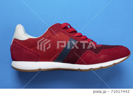 Stylish red sneakers on color background 71017442