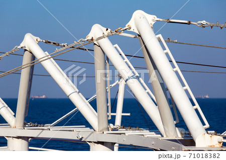 deck tensioners close-up of mounts and tensioning cables of the structure against a blue sky and sea during the day, nobody. deck tensioners close-up of mounts and tensioning cables of the structure against a blue sky and sea during the day, nobody. 71018382