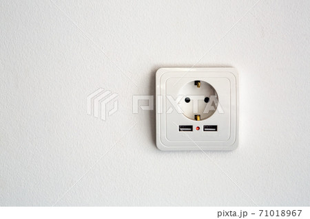 universal power socket European standard 220 volt with two connectors usb for charging mobile devices. socket white plastic on a white wall with copy space for text. 71018967
