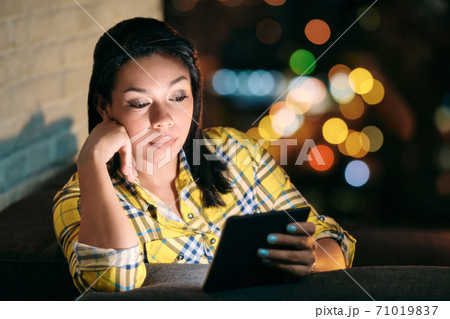 Young Woman Holding Ereader And Reading Ebook At Night Young Woman Holding Ereader And Reading Ebook At Night 71019837