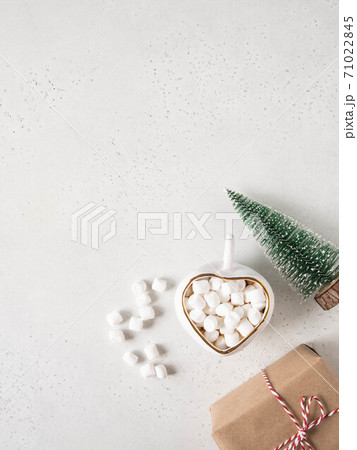 Cup with hot drink, gift and Christmas tree 71022845