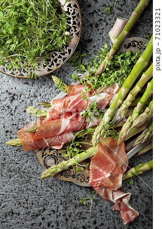 Asparagus wrapped in prosciutto with cress salad . Asparagus wrapped in prosciutto with cress salad . 71023321