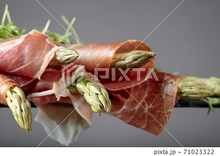 Asparagus wrapped in prosciutto . Asparagus wrapped in prosciutto . 71023322