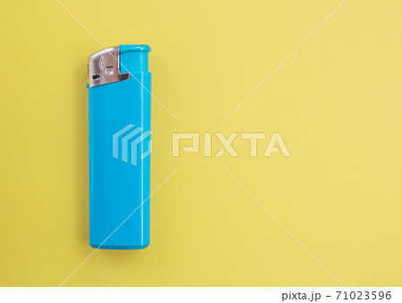 A turquoise lighter on a bright colored background with copy space. Smoking concept A turquoise lighter on a bright colored background with copy space. Smoking concept 71023596