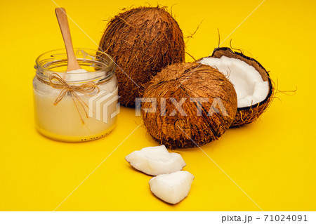 Parts of coconut on a colored background. Close up. Fresh ripe coconut broken into pieces. Coconut oil. Parts of coconut on a colored background. Close up. Fresh ripe coconut broken into pieces. Coconut oil. 71024091