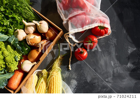 Fresh fruits and vegetables in reusable shopping bags. Fresh fruits and vegetables in reusable shopping bags. 71024211