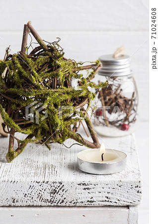 Decorative star with moss and lit candle 71024608
