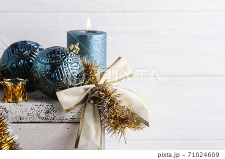 Chritmas golden bow, blue balls and lit candle 71024609