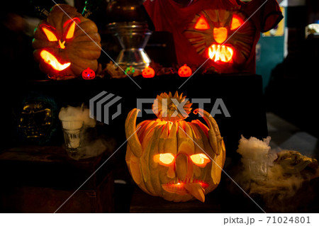 Halloween pumpkins head lantern with scary jack faces in dark 71024801