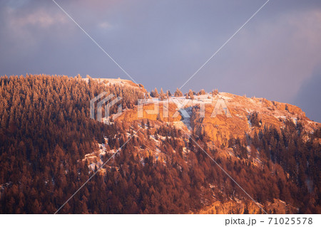 Winter nature scenery with a rocky mountainside covered with snow at sunset. Winter nature scenery with a rocky mountainside covered with snow at sunset. 71025578