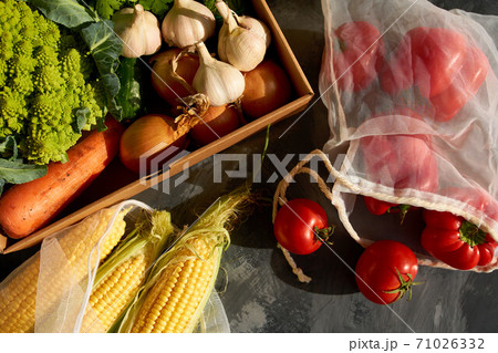 Fresh fruits and vegetables in reusable shopping bags. Fresh fruits and vegetables in reusable shopping bags. 71026332