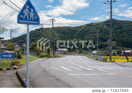晴れた日の山のある田舎の道と生徒が歩く横断歩道 71027093