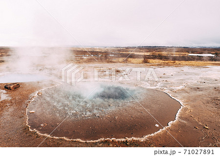 Geyser Valley in the southwest of Iceland. The famous tourist attraction Geysir. Geothermal zone Haukadalur. Strokkur geyser on the slopes of Laugarfjall hill. 71027891