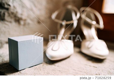 Bride's shoe ring box in white in a room with shallow depth of field. Bride's shoe ring box in white in a room with shallow depth of field. 71028259