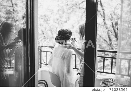 makeup artist does makeup to the bride during the preparation for the ceremony 71028565