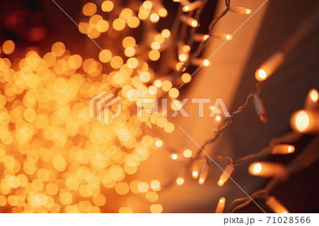 Festive background with LED lights garland. Christmas and New Year background. Blurred bokeh from the lights of a garland. 71028566