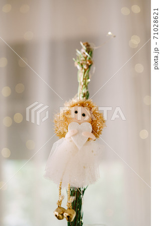 Christmas tree toy on top of a tree - a little girl with a heart in her hands. 71028621