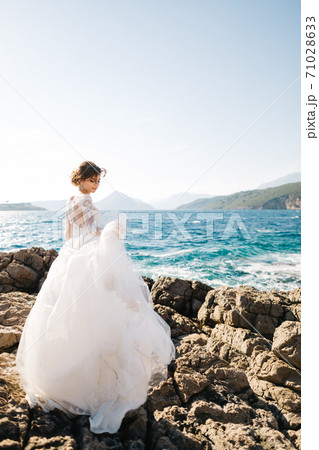beautiful bride in tender wedding dress on the rocky beach of the Mamula island 71028633