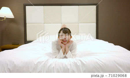 ホテルのベッドの上ではしゃいでいる女性 ホテルのベッドの上ではしゃいでいる女性 71029068