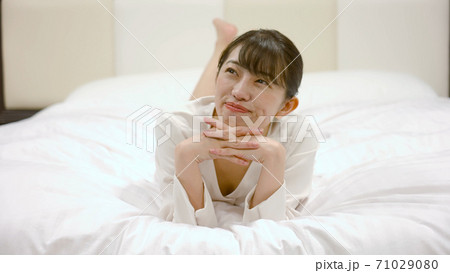 ホテルのベッドの上ではしゃいでいる女性	 71029080