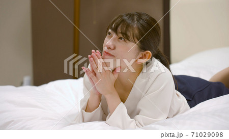 ホテルのベッドの上ではしゃいでいる女性 ホテルのベッドの上ではしゃいでいる女性 71029098