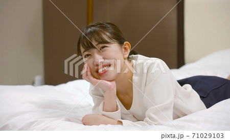 ホテルのベッドの上ではしゃいでいる女性 ホテルのベッドの上ではしゃいでいる女性 71029103