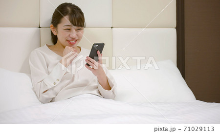 ホテルのベッドの上ではしゃいでいる女性 ホテルのベッドの上ではしゃいでいる女性 71029113