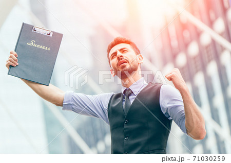 Successful latin businessman glad expression hand rising outdoors at business office outdoors. Successful latin businessman glad expression hand rising outdoors at business office outdoors. 71030259