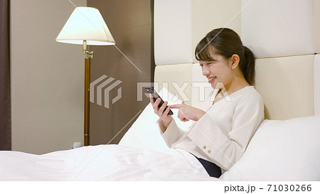 ホテルのベッドの上ではしゃいでいる女性 ホテルのベッドの上ではしゃいでいる女性 71030266