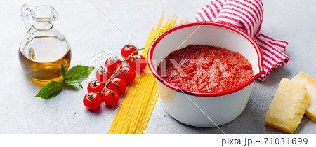 Traditional tomato sauce in saucepan with spaghetti pasta. Grey background. Close up. 71031699