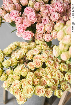 Big luxury bright bouquet peony rose on wooden table. Garden spray roses of lilac, pink and green color . bouquet in metal vase 71032804