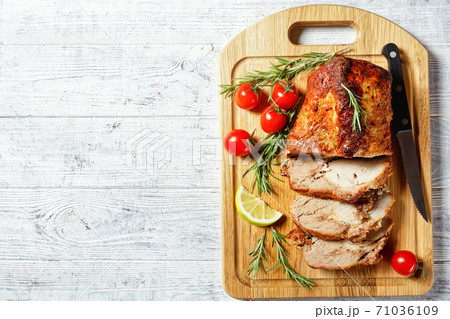 Sliced roasted pork on a white wooden background 71036109