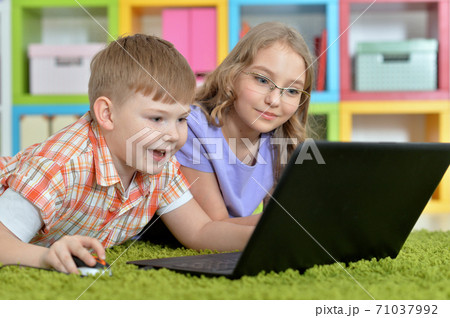 Brother and sister using laptop at home Brother and sister using laptop at home 71037992